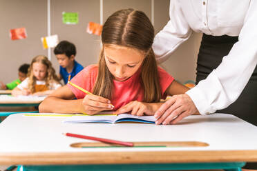 Gemischtrassige Gruppe von Kindern in der Grundschule - Verspielte Schüler genießen die Schulzeit und den Unterricht mit Lehrern und Mitschülern - DMDF02388