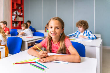 Gemischtrassige Gruppe von Kindern in der Grundschule - Verspielte Schüler genießen die Schulzeit und den Unterricht mit Lehrern und Mitschülern - DMDF02389