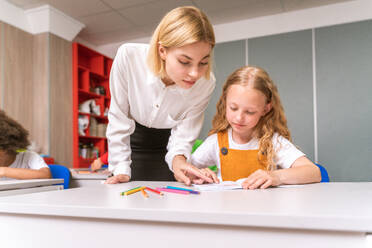 Gemischtrassige Gruppe von Kindern in der Grundschule - Verspielte Schüler genießen die Schulzeit und den Unterricht mit Lehrern und Mitschülern - DMDF02392