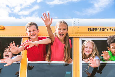 Group of young students attending primary school on a yellow school bus - Elementary school kids ha1ving fun - DMDF02397