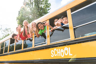 Group of young students attending primary school on a yellow school bus - Elementary school kids ha1ving fun - DMDF02398