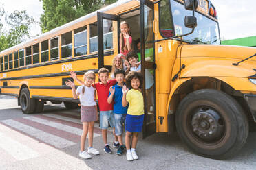 Group of young students attending primary school on a yellow school bus - Elementary school kids ha1ving fun - DMDF02401