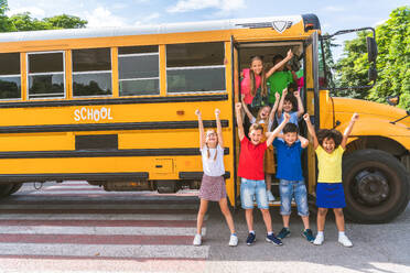 Group of young students attending primary school on a yellow school bus - Elementary school kids ha1ving fun - DMDF02402