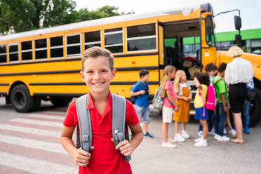 Group of young students attending primary school on a yellow school bus - Elementary school kids ha1ving fun - DMDF02409