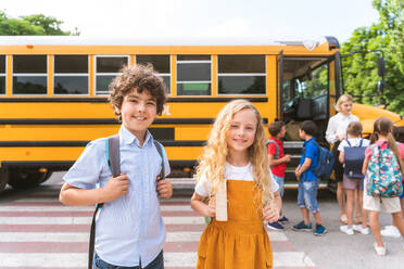 Group of young students attending primary school on a yellow school bus - Elementary school kids ha1ving fun - DMDF02416