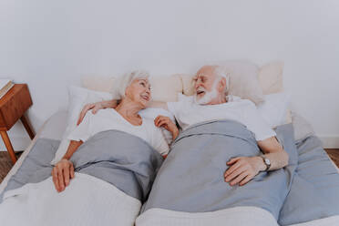 Beautiful senior couple enjoying time together at home - Romantic moments at home, elderly couple in bed at home - DMDF02488