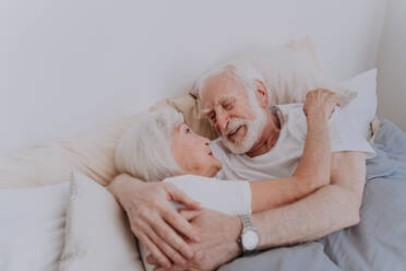 Beautiful senior couple enjoying time together at home - Romantic moments at home, elderly couple in bed at home - DMDF02490