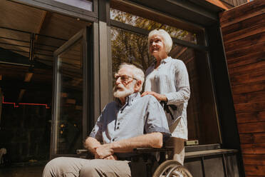 Disabled old man on wheel chair - Senior couple at home, partner coming back from hospital in convalescence - DMDF02507