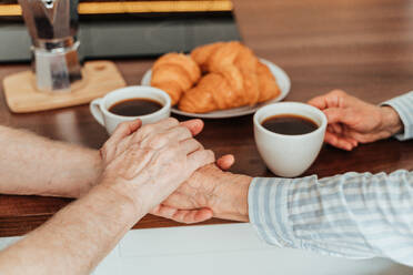 Senior couple having breakfast at home - Elderly people daily life in the moning - DMDF02527