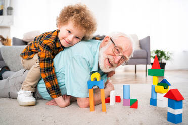 Grandparents and grandson playing at home - Family at home, grandfather taking care of nephew - DMDF02541