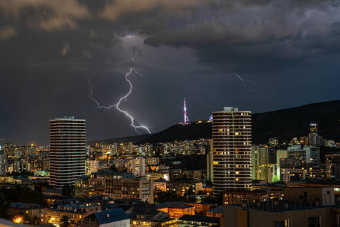 Dramatic sky with lightnings in stormy night over Tbilisi's downtown - ADSF46585