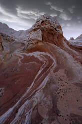 Picturesque scenery of rough rocky mountains under cloudy dark sky in evening - ADSF46620