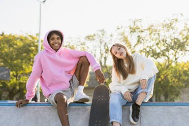 Multicultural group of young friends bonding outdoors and having fun - Stylish cool teens gathering at urban skate park - DMDF02573