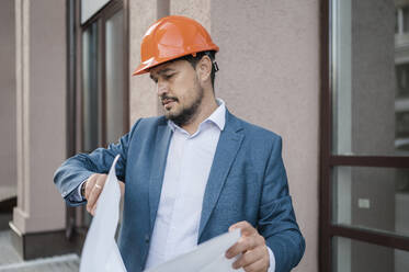 Engineer checking time in front of building - ANAF01941