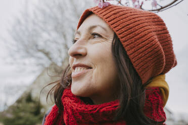 Thoughtful woman wearing scarf and knit hat - OSF01991