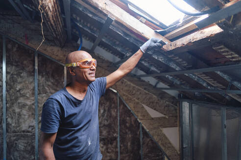 Happy construction worker wearing protective glasses - ASGF04316