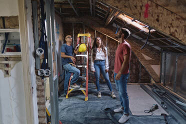 Man and woman having discussion with construction worker at construction site - ASGF04394