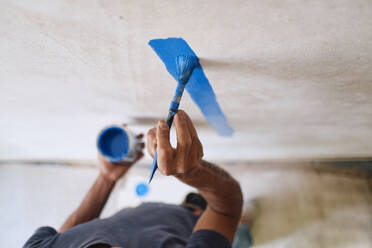 Construction worker painting wall with brush - ASGF04408