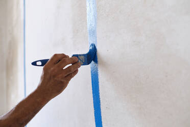 Hand of construction worker painting on wall with brush - ASGF04414