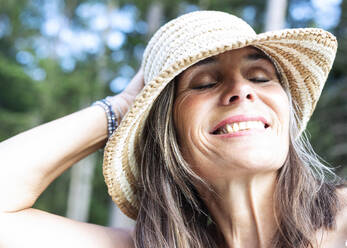Smiling mature woman wearing hat - JBYF00239