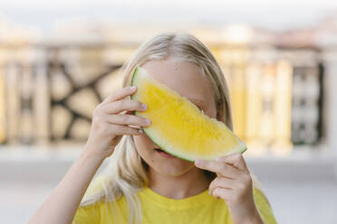 Girl covering her face with yellow watermelon - SIF00798