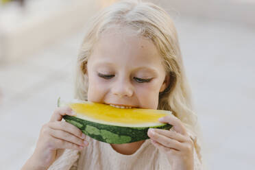 Girl eating fresh yellow watermelon - SIF00804