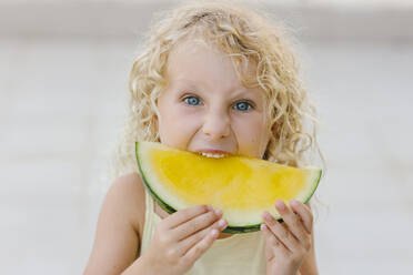 Blondes Mädchen beißt in ein Stück gelbe Wassermelone - SIF00807