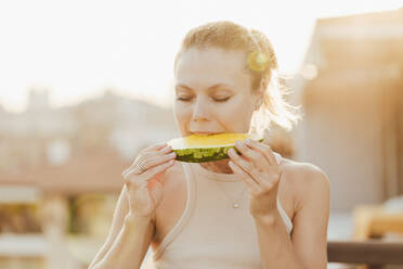 Frau isst ein Stück gelbe Wassermelone - SIF00808