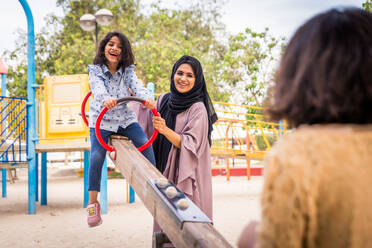 Happy arabian family having fun in Dubai - Mom together with her daughters in park play area - DMDF02602