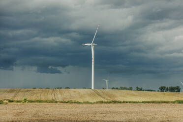 Windkraftanlagen auf einem Feld unter bewölktem Himmel - VSNF01295