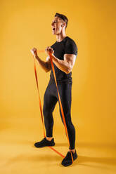 Athletic man with fit muscular body training in studio - Active man doing a workout, colorful lighting and background, concepts about fitness, sport and health lifestyle - DMDF02631