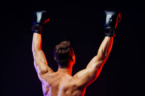 Athletic man with fit muscular body training in studio - Active man doing a workout, colorful lighting and background, concepts about fitness, sport and health lifestyle - DMDF02739