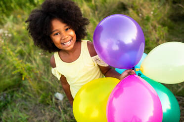 Pretty afro american girl in a sunflowers field having fun - DMDF02764