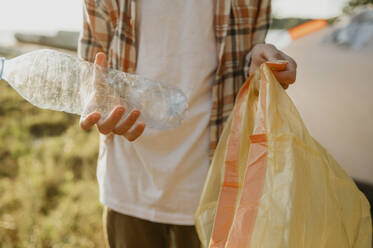 Teenager collecting bottles in plastic bag - ANAF01957