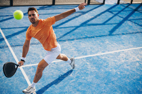 Padel-Sportler beim Üben seiner Schlagtechnik in einer Trainingseinheit. Der Sportler arbeitet an der Kontrolle seines Schlägers, um sich auf künftige Wettkämpfe und Turniere vorzubereiten. Bei diesem Foto wurde absichtlich das Korn des 35-mm-Films verwendet. - JLPPF02348