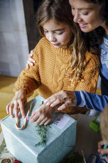 Familie dekoriert Geschenkbox zu Hause - IKF01157