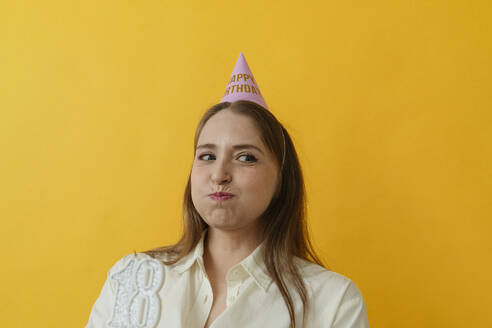 Playful woman making face against yellow background - OSF02009