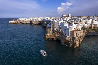 Aerial view of a boat sailing off the coast of Polignano a Mare fishing village, Bari, Apulia, Adriatic Sea, Mediterranean Sea, Italy, Europe - RHPLF26935