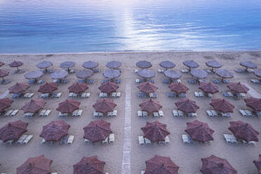 Aerial view of large group of tidy beach umbrellas facing the Mediterranean Sea, Italy, Europe - RHPLF26939