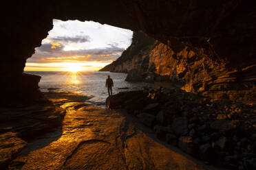 A boy admires a beautiful spring sunset from the Byron cave, Portovenere, La Spezia province, Liguria district, Italy, Europe - RHPLF26942