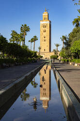 Ancient minaret tower of Koutoubia Mosque, UNESCO World Heritage Site, reflected in water in a palm fringed park, Marrakech, Morocco, North Africa, Africa - RHPLF27004
