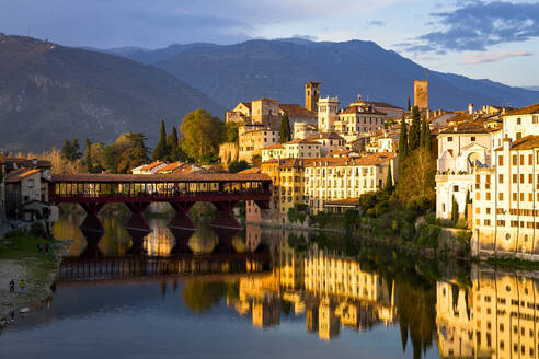 Sunset over the iconic Ponte Vecchio bridge reflected in river Brenta, Bassano Del Grappa, Vicenza province, Veneto, Italy, Europe - RHPLF27010