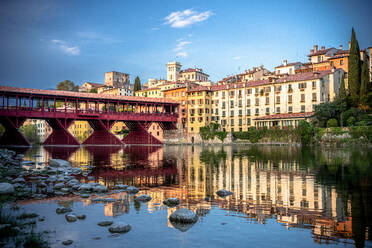 Sunset over the iconic Ponte Vecchio bridge reflected in river Brenta, Bassano Del Grappa, Vicenza province, Veneto, Italy, Europe - RHPLF27012