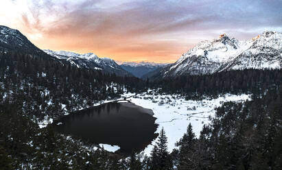Aerial panoramic view of snowy forest and frozen lake Entova at sunrise, Valmalenco, Valtellina, Lombardy, Italy, Europe - RHPLF27016