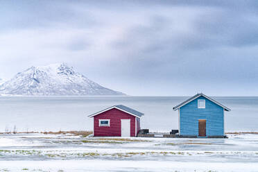 Traditional rorbu cabins overlooking the frozen sea, Troms county, Norway, Scandinavia, Europe - RHPLF27036