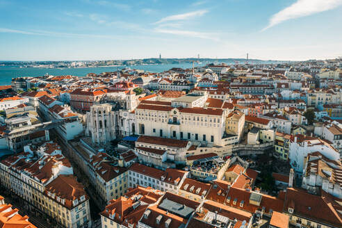 Aerial drone view of Carmo Church and surrounding historic neighbourhood in Chiado, with Tagus River and 25 April Bridge visible, Lisbon, Portugal, Europe - RHPLF27083