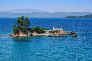 Small Christian church stone-built chapel with a cross on a small island strip in calm sea, Greek Islands, Greece, Europe - RHPLF27136