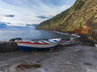 Some boats on a pier below a cliff in Sao Miguel Island in the Azores, Portugal, Atlantic, Europe - RHPLF27189