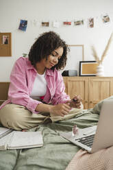 Smiling teenager applying nail polish at home - ALKF00536