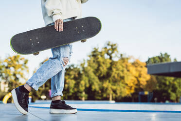 Stylish cool teen female skateboarder at skate park - DMDF02921